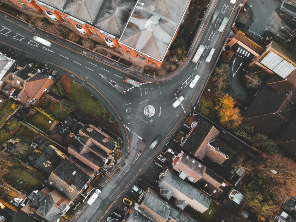 Top-down aerial shot of a residential area roundabout in Guildford, showcasing urban architecture and traffic.